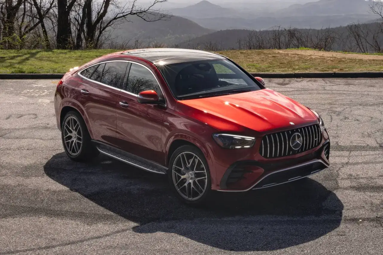 Czerwony Mercedes-AMG GLE coupe z panoramicznym dachem, zaparkowany na tle górskiego krajobrazu.