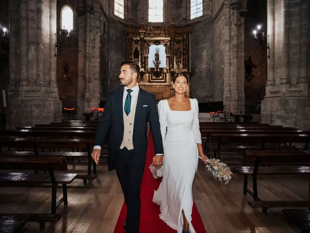 Novios sonriendo y caminando por el pasillo de una iglesia, listos para sus votos matrimoniales divertidos.