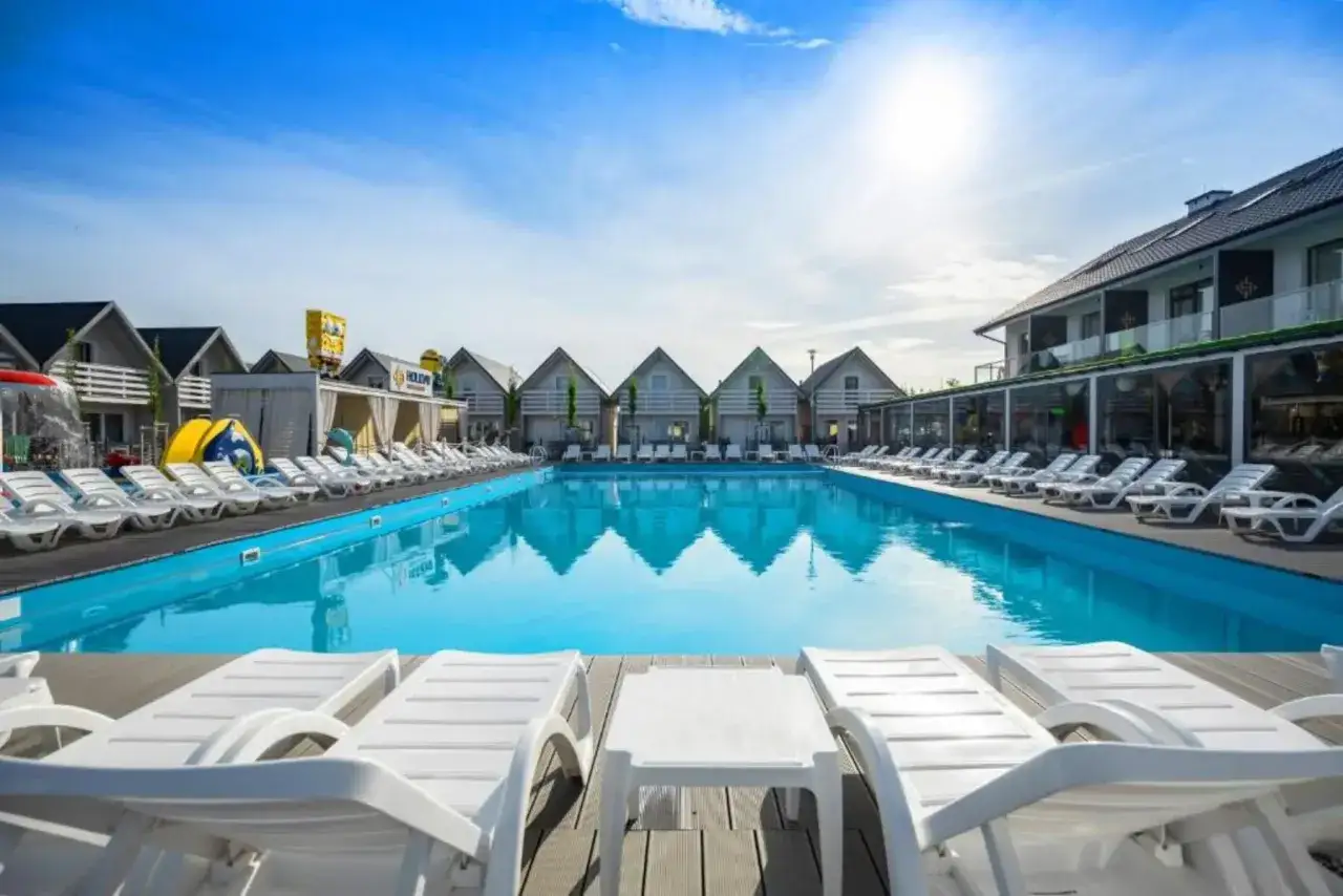 Słoneczny basen z leżakami w holiday park & resort Grzybowo. Opinie o tym miejscu są świetne!