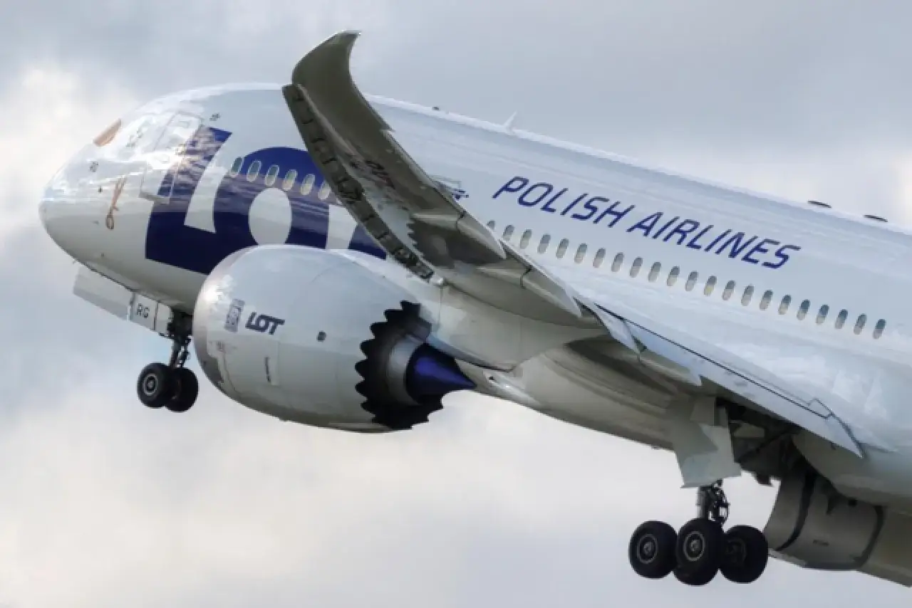 Samolot LOT Polish Airlines w locie, widok z boku na silnik i skrzydło.
