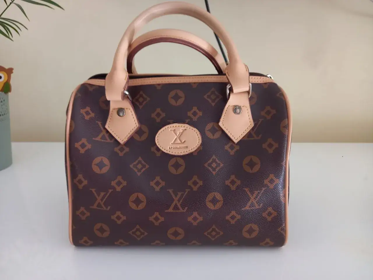 Brązowa louis vuitton torebka kuferek z monogramem. Elegancka, z jasnymi rączkami i detalami.