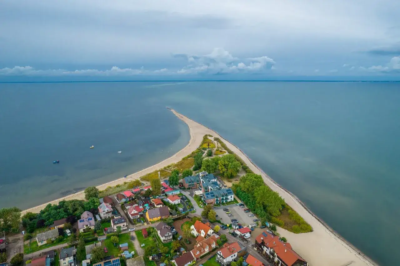 Widok z lotu ptaka na nadmorską miejscowość z plażą i morzem.