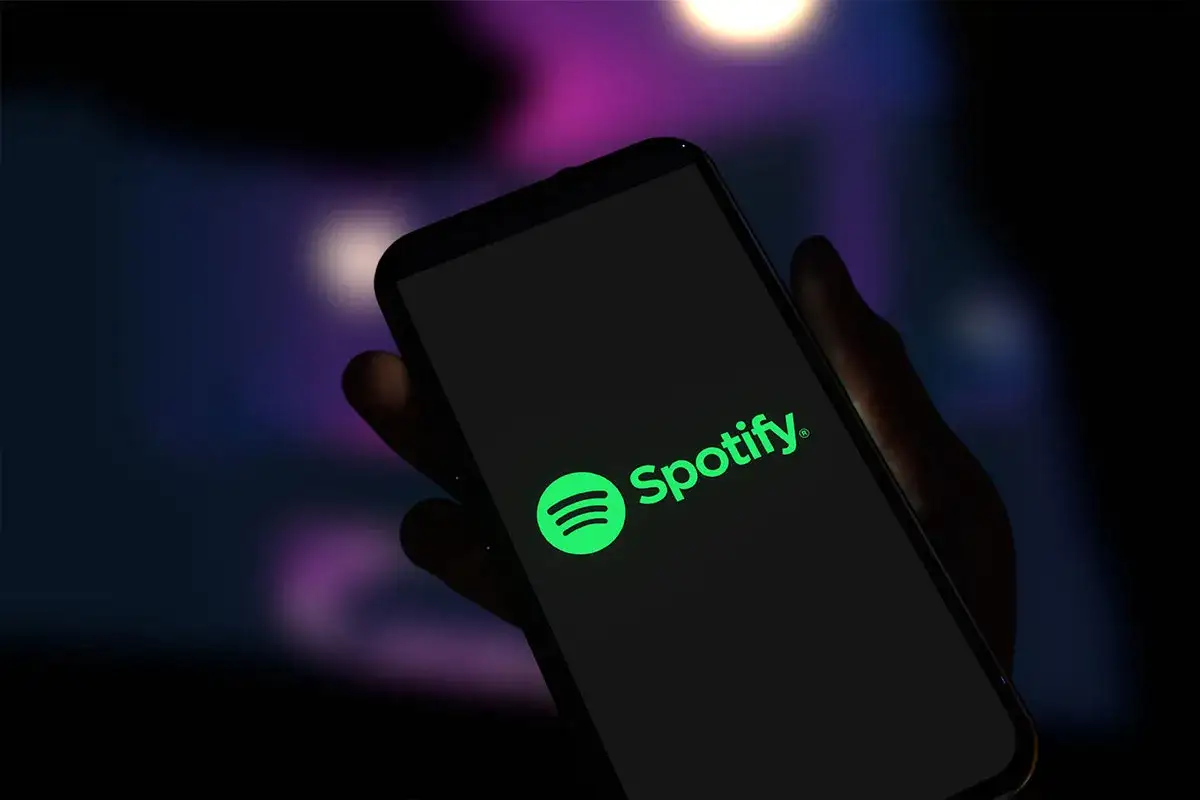 Dłoń trzyma smartfon z logo Spotify. Czas na podsumowanie roku, kiedy Spotify Wrapped!