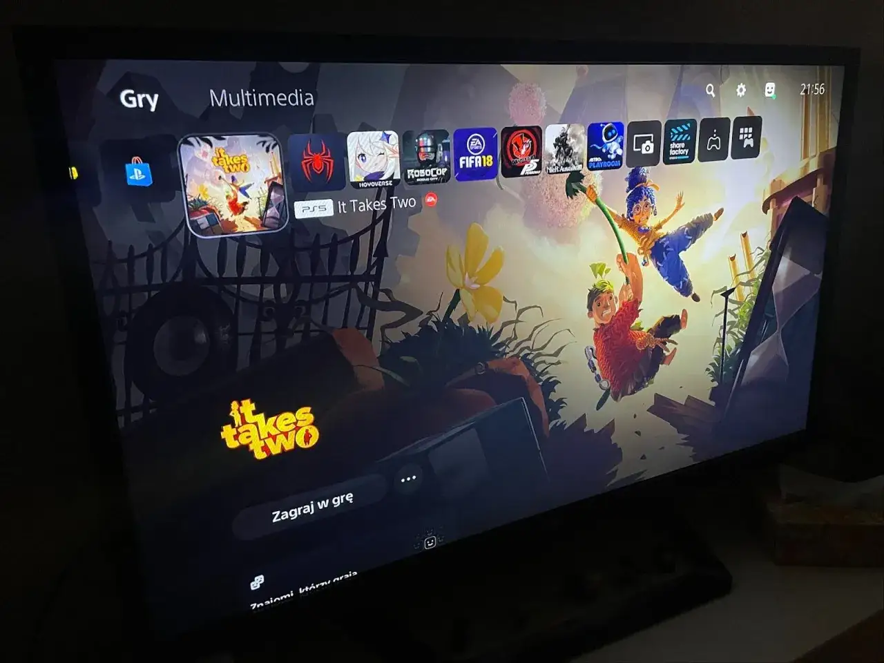 Ekran PlayStation z grą "It Takes Two". Widać też ikony innych gier, w tym FIFA 18, co sugeruje dostępność przez EA Play Pro na Xbox.