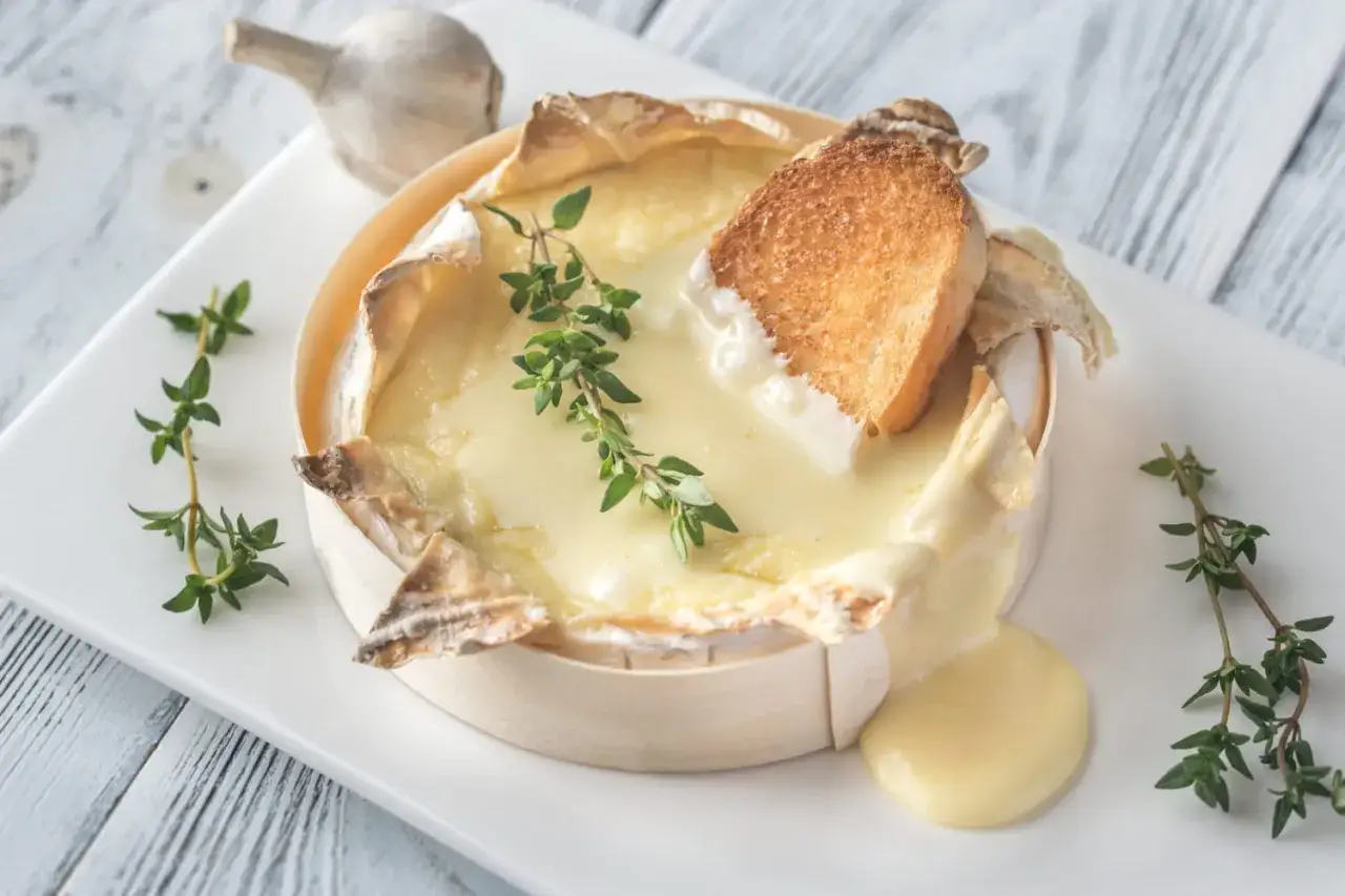 Un camembert coulant, spécialité normandie, servi avec du pain grillé et du thym. Un délice !