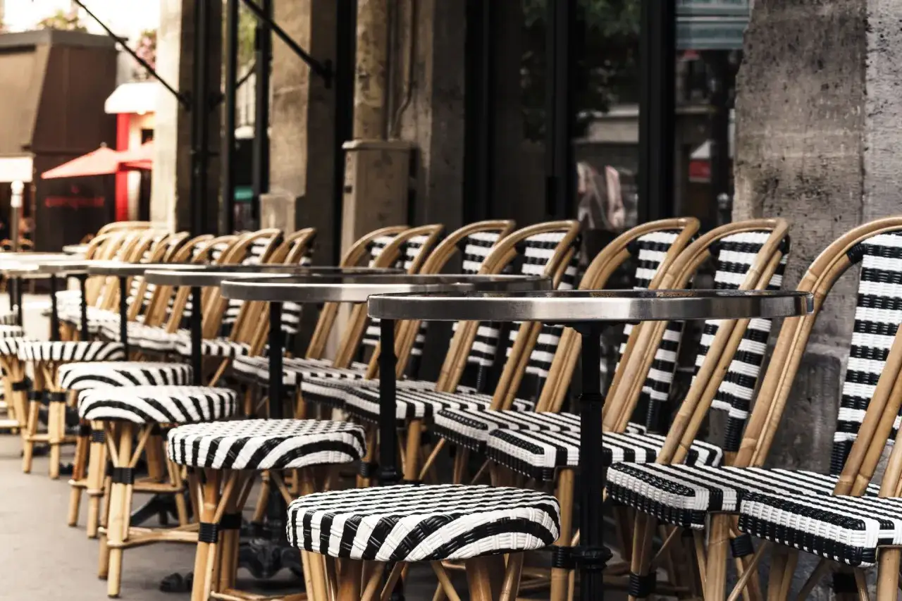Terrasses parisiennes avec chaises et tabourets rayés, prêts à accueillir les gourmands pour déguster les spécialités paris.