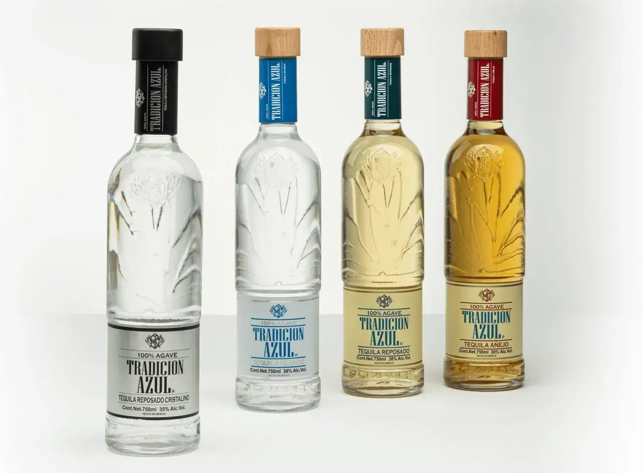 Cztery butelki tequili Tradicion Azul: blanco, reposado cristalino, reposado i añejo. Różnica między tequilą blanco, reposado a añejo w smaku i cenie jest widoczna w kolorze i etykietach.