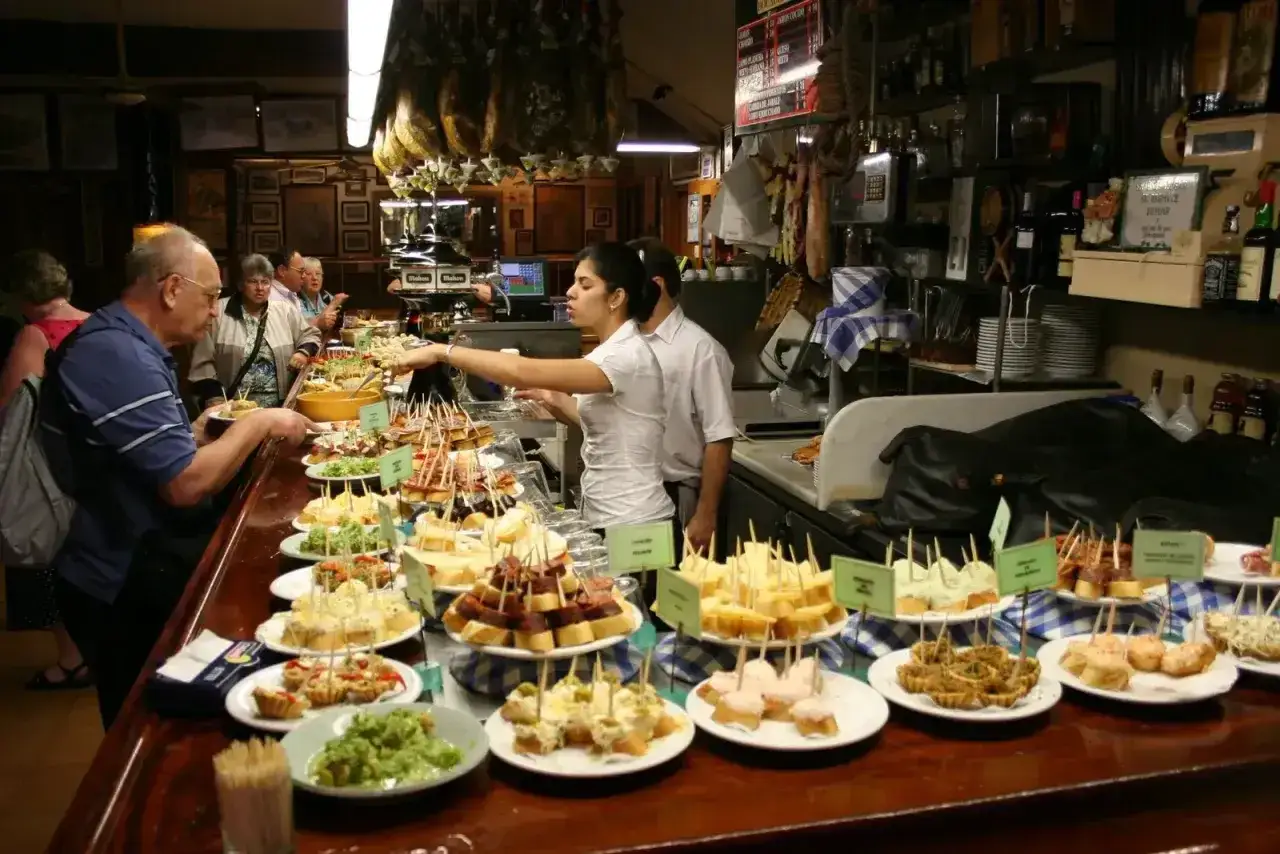 Wybór pysznych tapas na barze, ludzie wybierają przekąski.