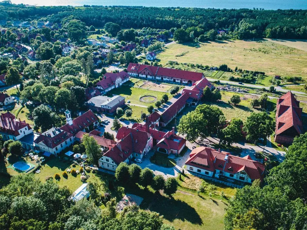 Widok z lotu ptaka na kompleks budynków hotelowych z czerwonymi dachami. Wiele pozytywnych kadyny folwark hotel & spa opinie potwierdza urok tego miejsca.