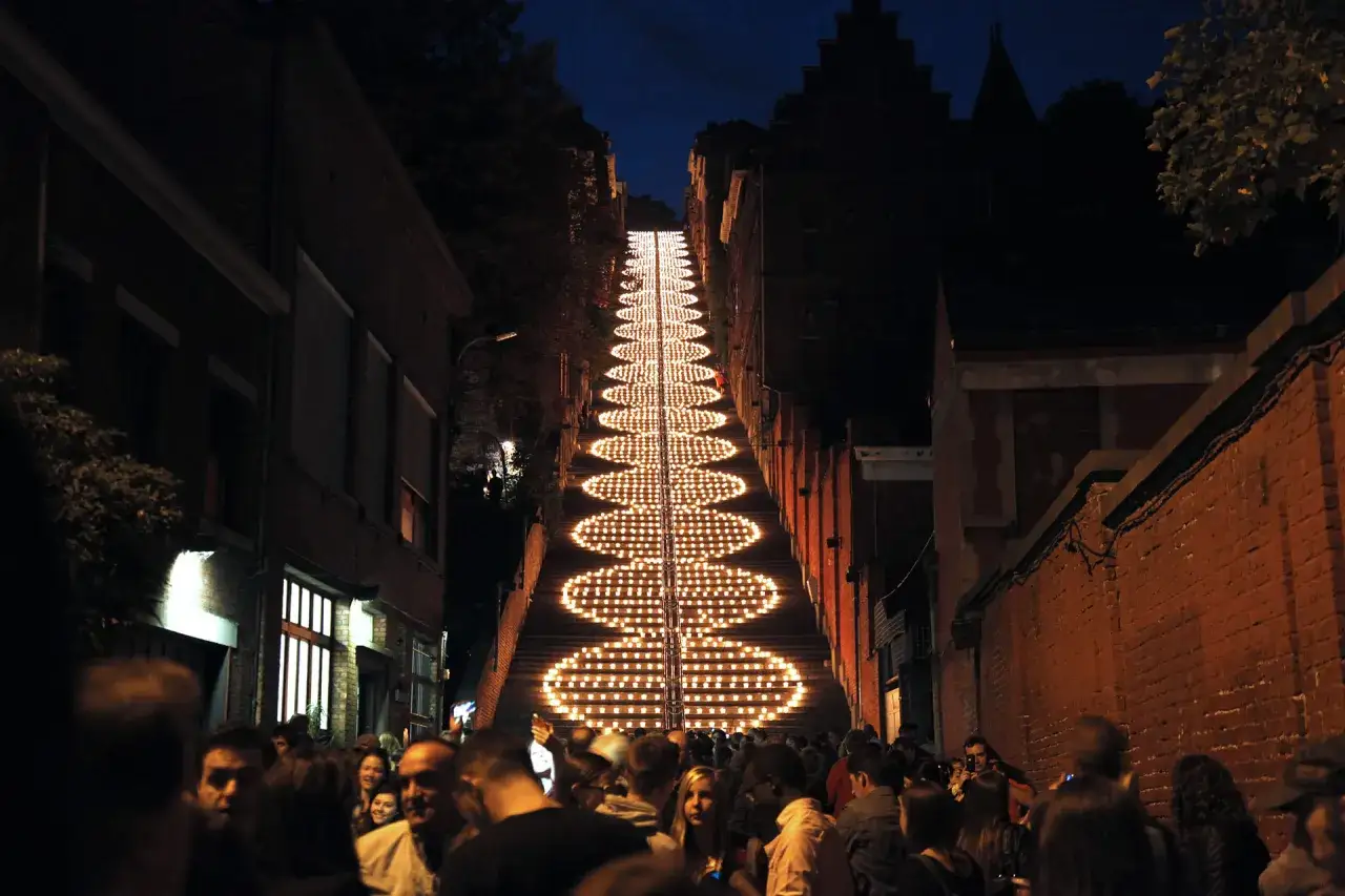 Beleuchtete Treppe in Büren bei Nacht, umgeben von Menschen und Gebäuden.