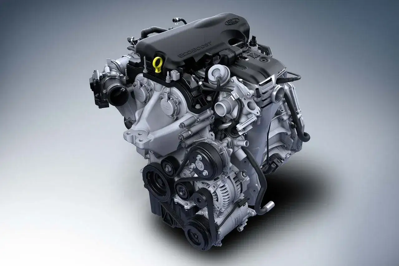 Silnik Ford EcoBoost z widocznymi paskami, kołami pasowymi i alternatorem.