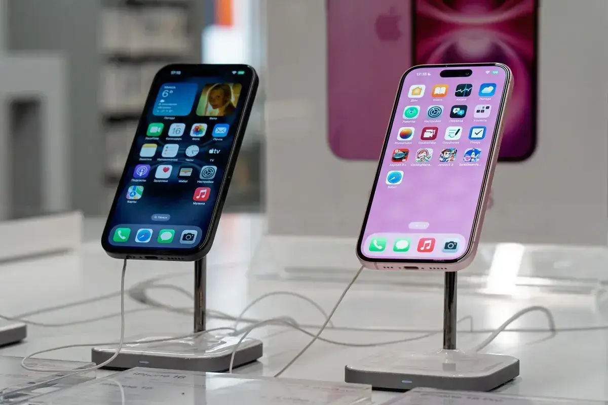 Dwa iPhone'y na wystawie sklepowej. Jeden czarny, drugi różowy. W tle widać różowy iPhone. Opłata reprograficzna może dotyczyć takich urządzeń.