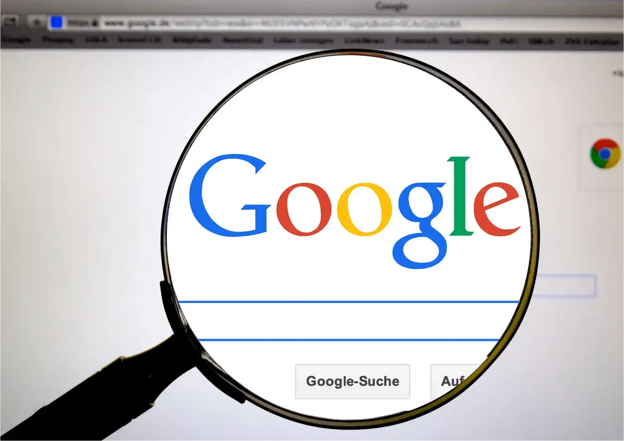 Lupa powiększa logo Google. Szukasz odpowiedzi na pytanie "co to za piosenka google"?