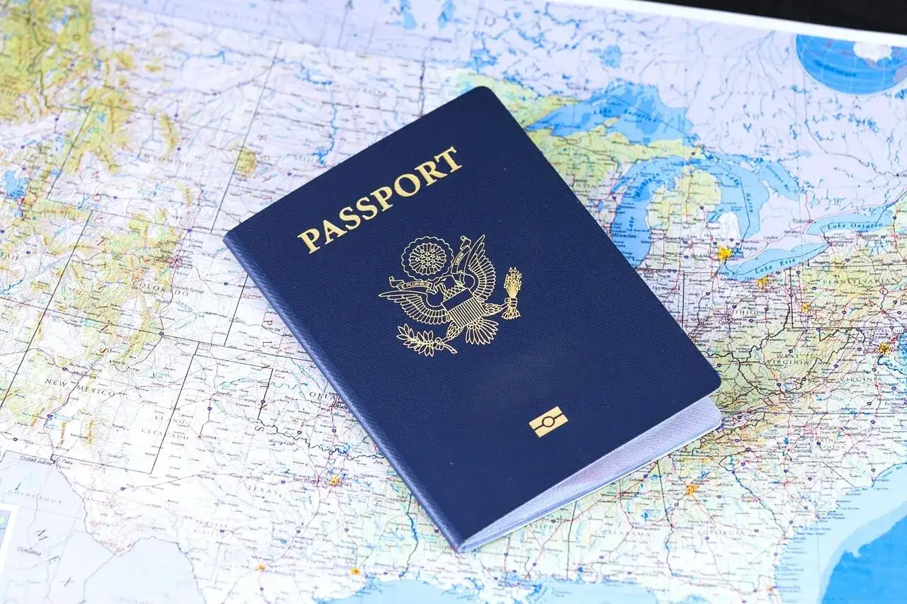 Granatowy paszport USA leżący na mapie Stanów Zjednoczonych.