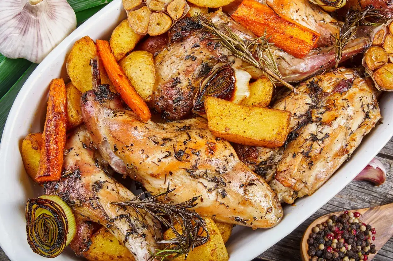 Pieczony królik z ziemniakami, marchewką i czosnkiem, doprawiony rozmarynem. Idealna marynata do królika pieczonego w piekarniku.