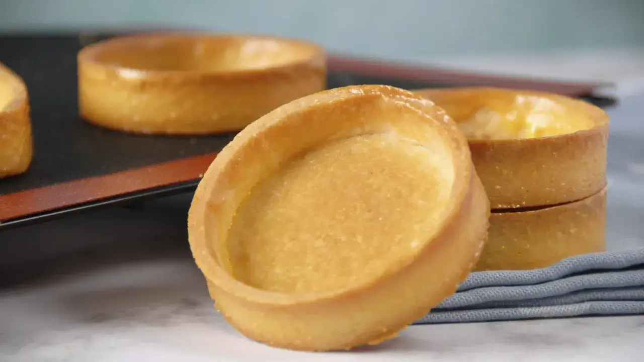 Fonds de tartelettes dorés, prêts pour une recette de pâte sucrée. Parfaits pour des desserts gourmands.