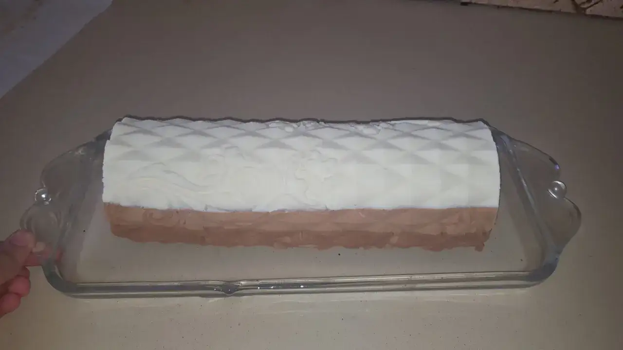 Un biscuit croustillant pour entremet, avec un décor en relief, est présenté dans un plat en verre.
