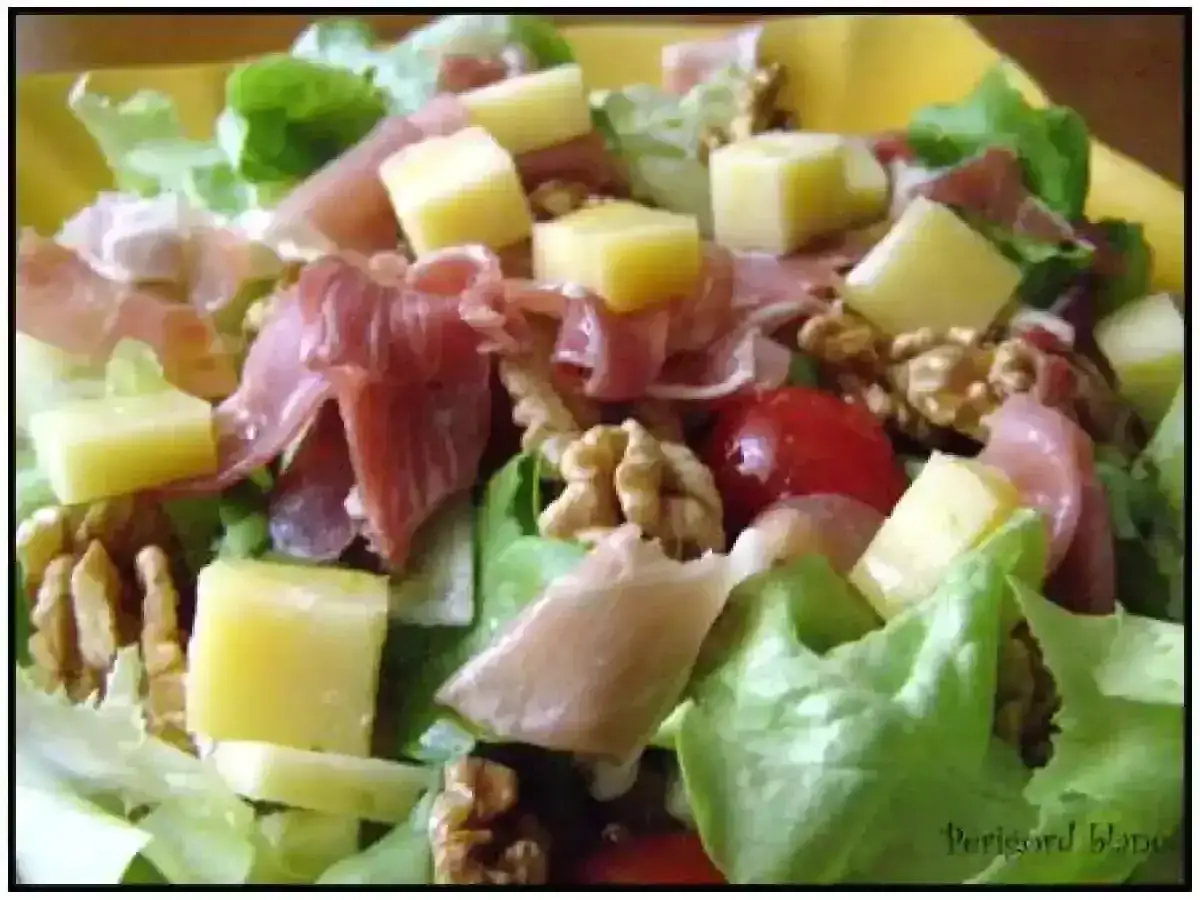 Salade fraîche avec jambon cru, dés de fromage, noix et tomates cerises. Une belle entrée auvergnate pour un repas léger.