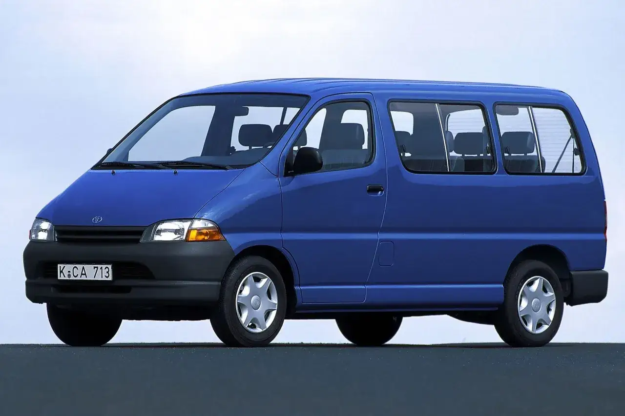 Niebieski van Toyota Hiace z lat 90. z widocznymi siedzeniami i oknami.