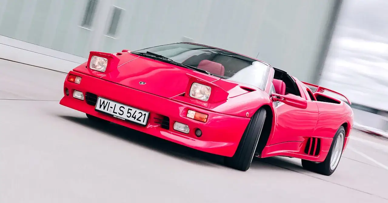 Czerwony samochód sportowy z podnoszonymi światłami i tablicą rejestracyjną WI-LS 5421.
