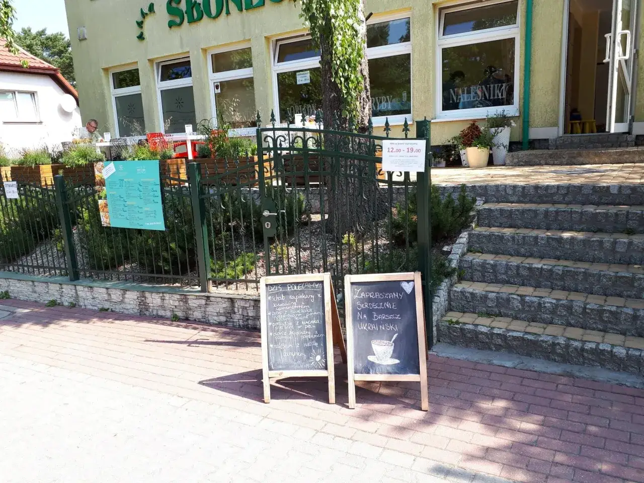 Gdzie zjeść w Jastrzębiej Górze? Dwie tablice przed restauracją zachęcają do spróbowania dań dnia i barszczu ukraińskiego.