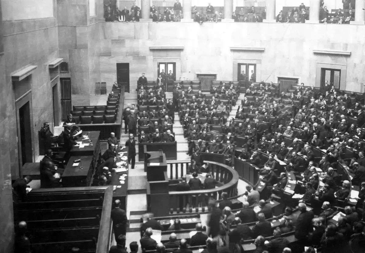 Posiedzenie sejmu w historycznej sali, z licznymi posłami siedzącymi w ławach.