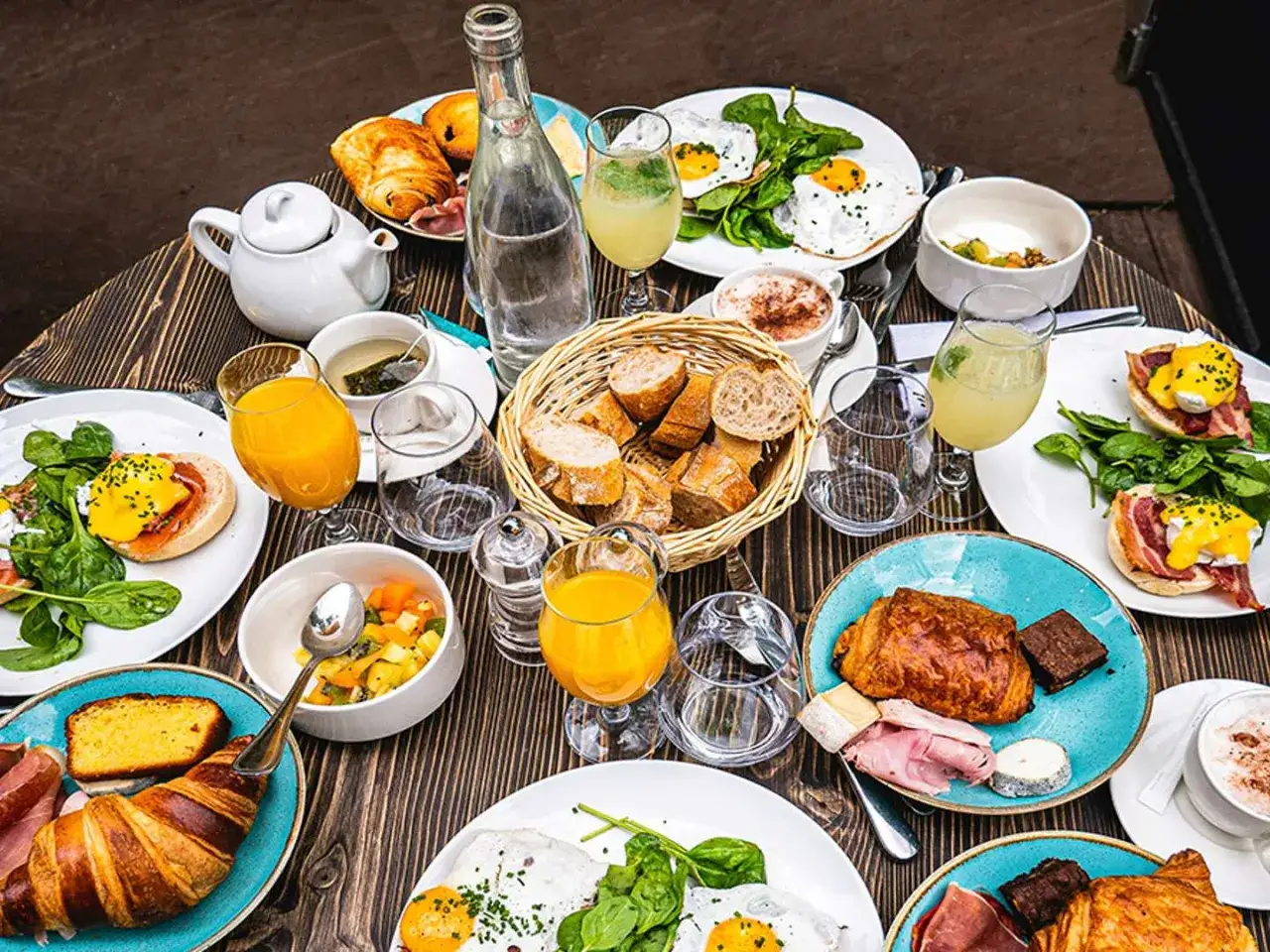 Un festin parisien : œufs Bénédicte, croissants, jus d'orange et café. Une spécialité parisienne pour un brunch gourmand.