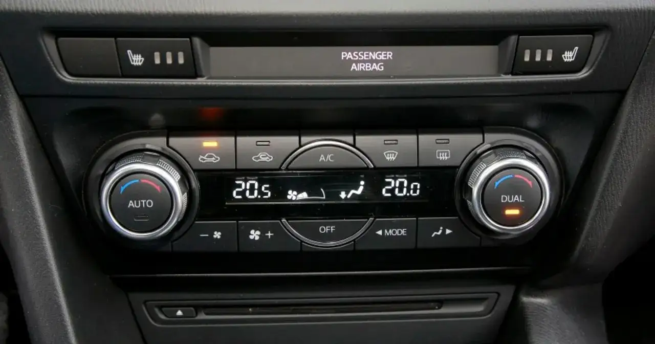 Panel sterowania klimatyzacją w samochodzie, z pokrętłami AUTO i DUAL, wyświetlaczem temperatury 20.5°C i ikonami nawiewu. Idealny do ozonowania klimatyzacji.
