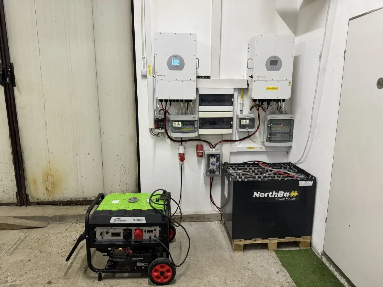 System fotowoltaiczny z magazynem energii. Widoczne falowniki, skrzynki elektryczne, agregat prądotwórczy i duży magazyn energii NorthBaH.