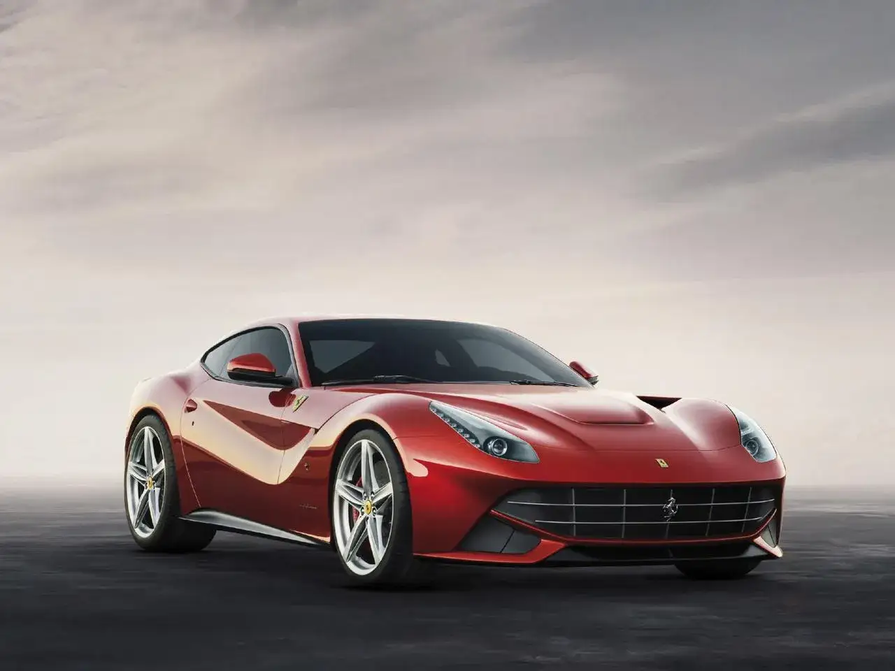 Czerwone Ferrari F12 Berlinetta błyszczy na tle pochmurnego nieba.