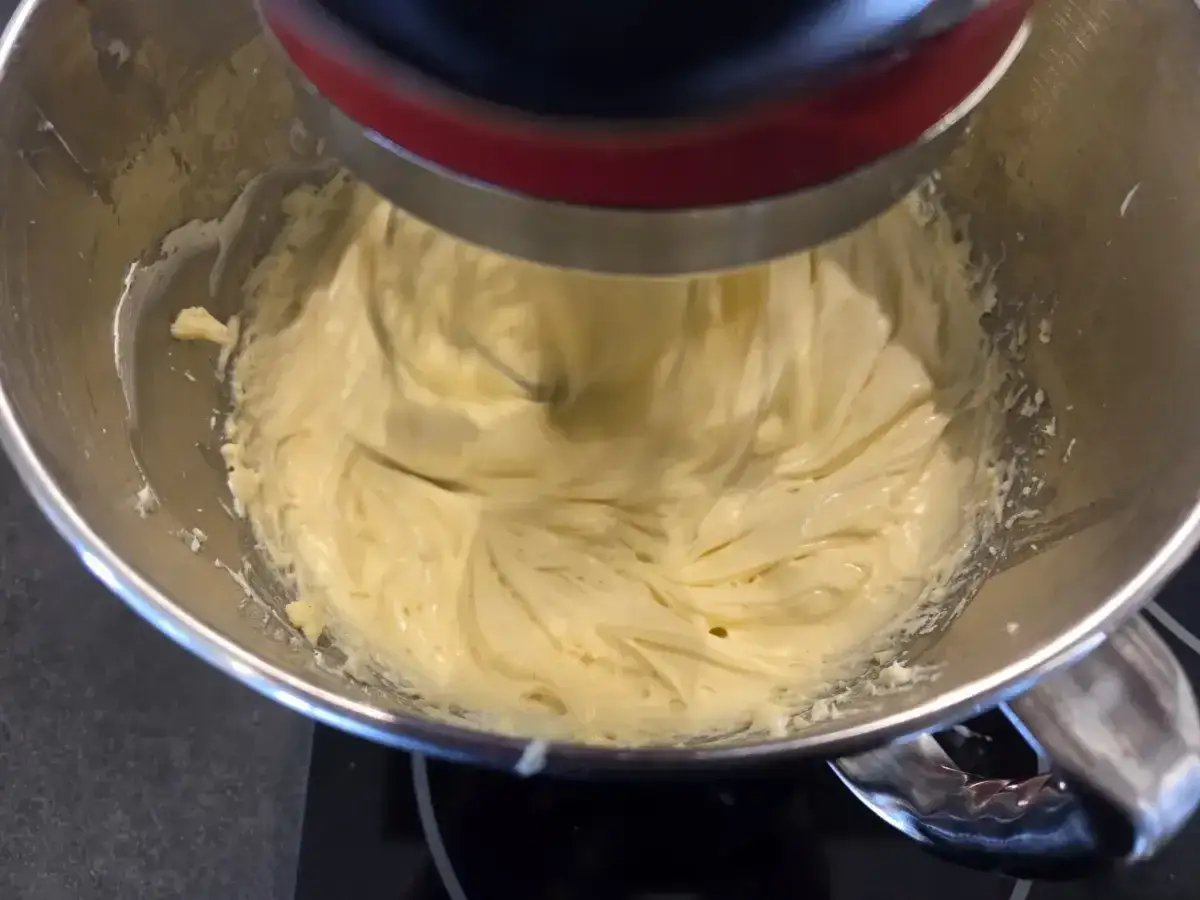 Un robot pâtissier mélange une crème onctueuse, prête à devenir une délicieuse crème mousseline café.