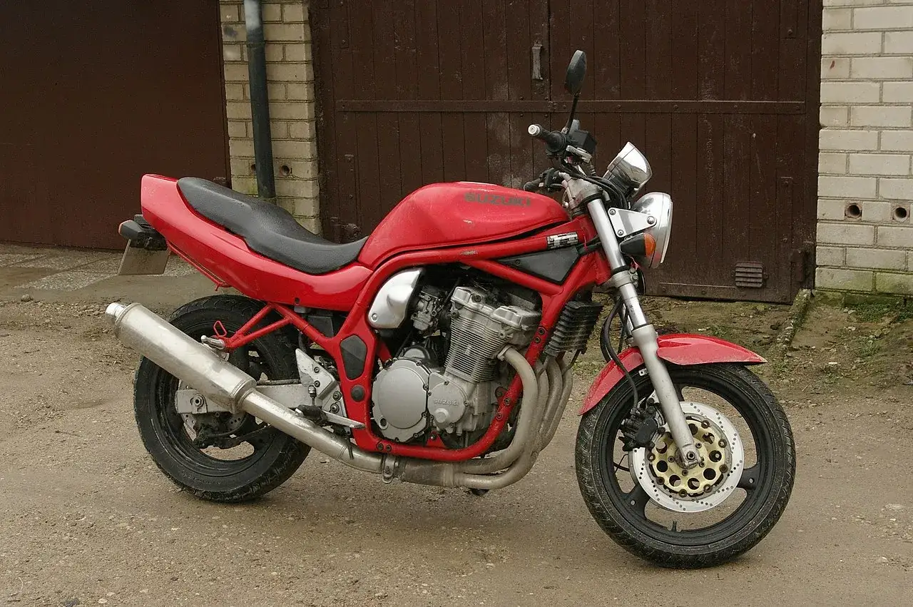 Czerwony Suzuki Bandit 600, gotowy do jazdy, z widocznym silnikiem i wydechem.