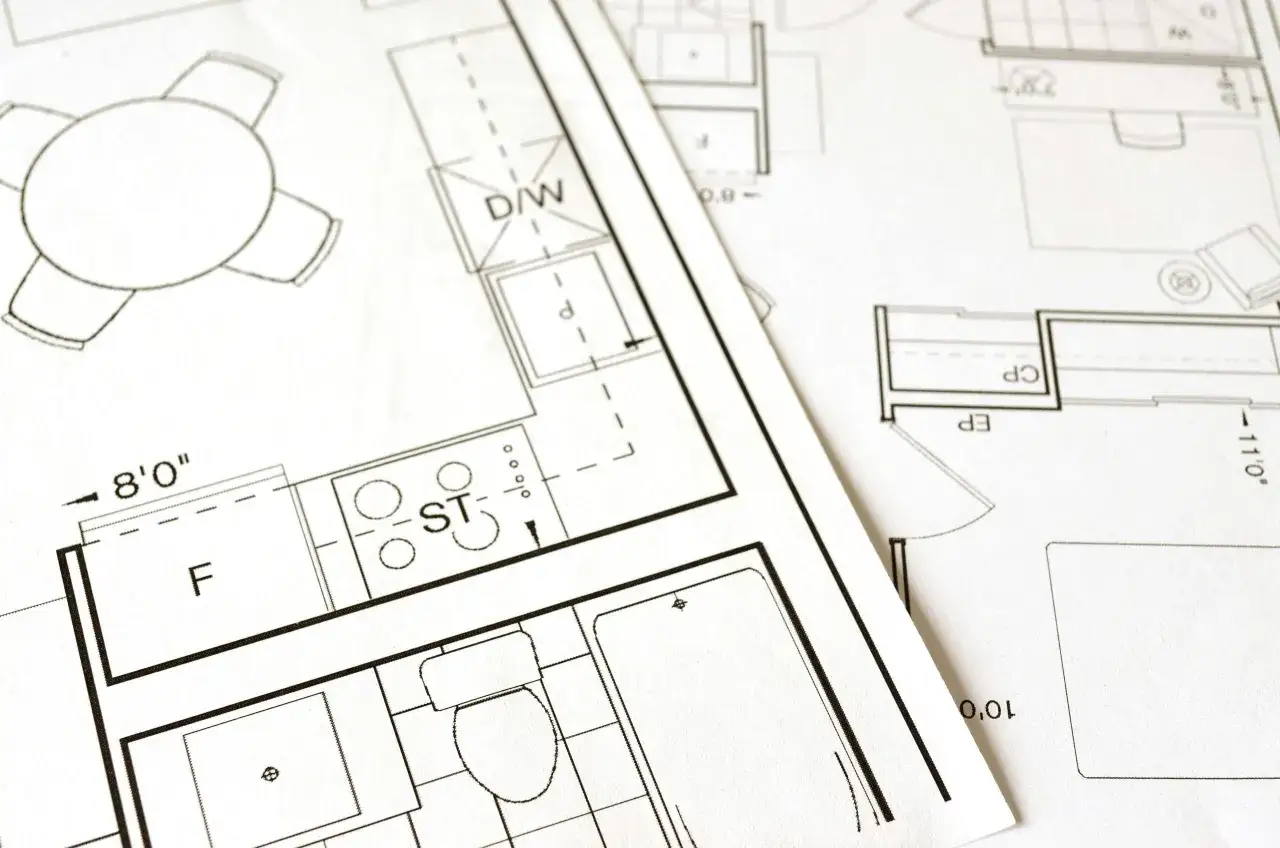 Plany architektoniczne z kuchnią, łazienką i stołem. Kluczowe etapy: warunki zabudowy a pozwolenie na budowę.
