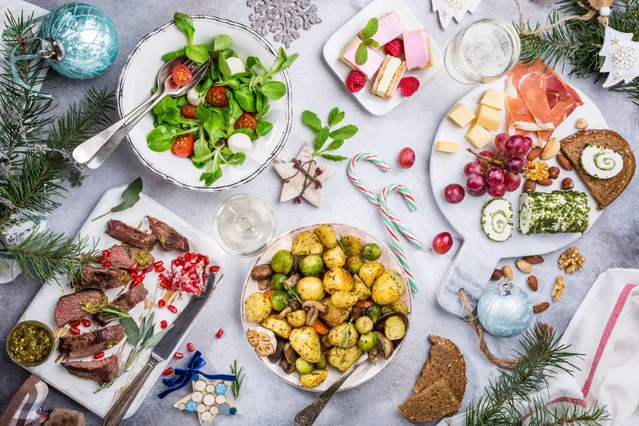 Wigilia na talerzu: pieczone ziemniaki, mięso, sałatka, ser, słodkości. Zastanawiasz się, ile kosztuje catering na wigilię?