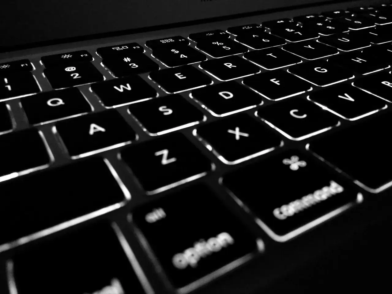 Podświetlane klawisze laptopa, w tym klawisze funkcyjne F1-F12, litery i symbole.