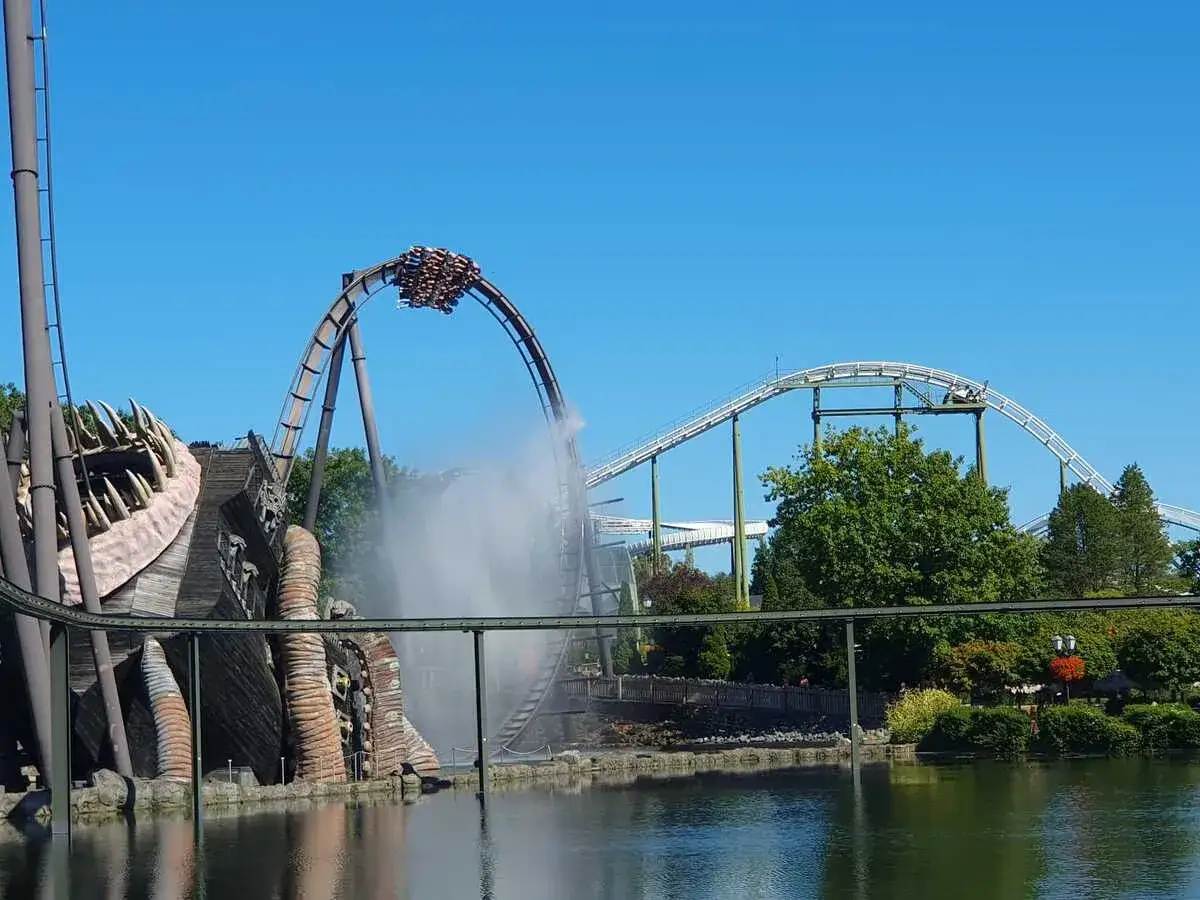 Achterbahn im Heide Park mit Wassereffekt und einem großen Holzmonster.