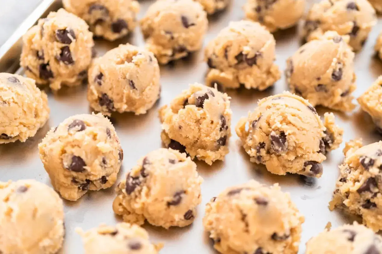 Boules de pâte à cookie au chocolat sur une plaque. Combien de temps la pâte à cookie au frigo se conserve-t-elle ?