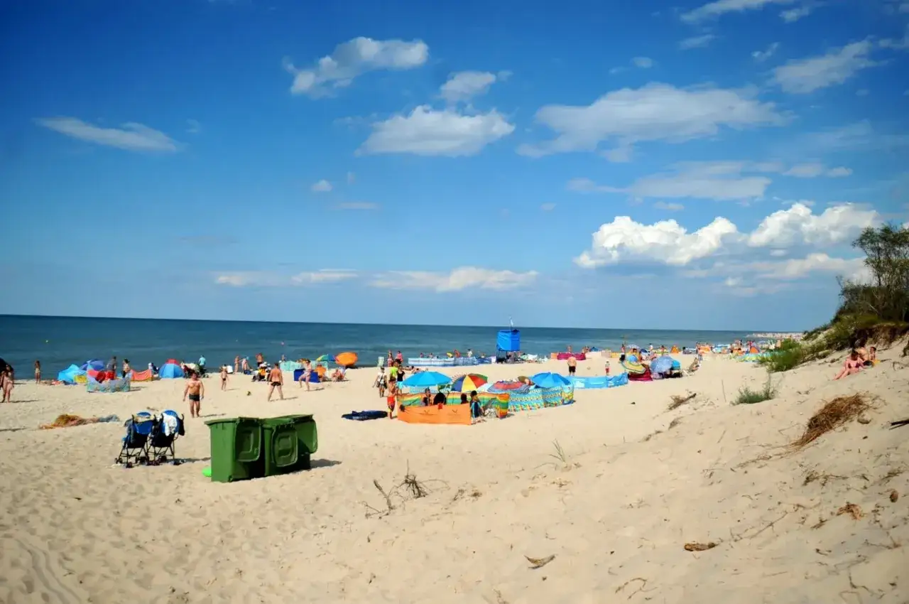 Plaża pełna ludzi, kolorowe parawany i namioty. Idealne miejsce, gdzie ciepła woda w czerwcu zachęca do kąpieli.