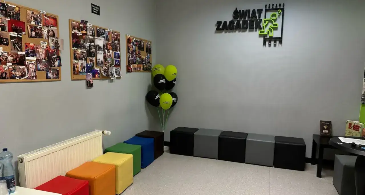 W poczekalni "Świat Zagadek" wiszą zdjęcia z przygód, balony i kolorowe pufy.