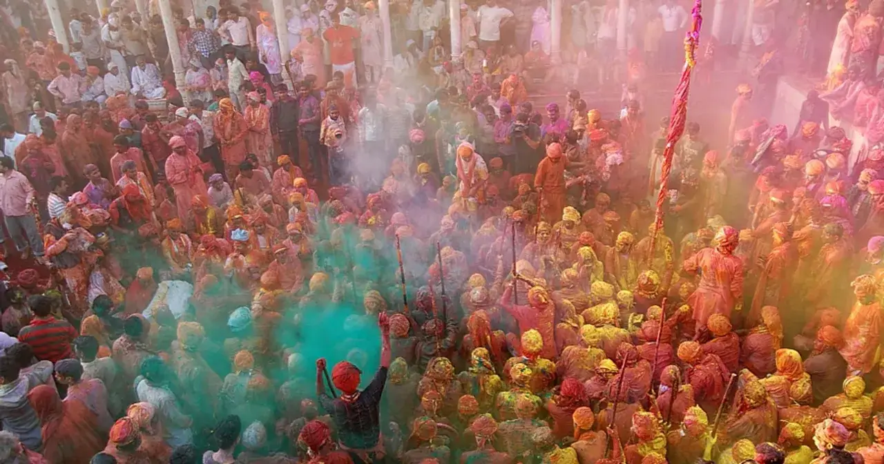 Tłum ludzi w kolorowym pyle podczas festiwalu Holi. To jedno z wielu barwnych festiwali na świecie, pełne radości i tradycji.