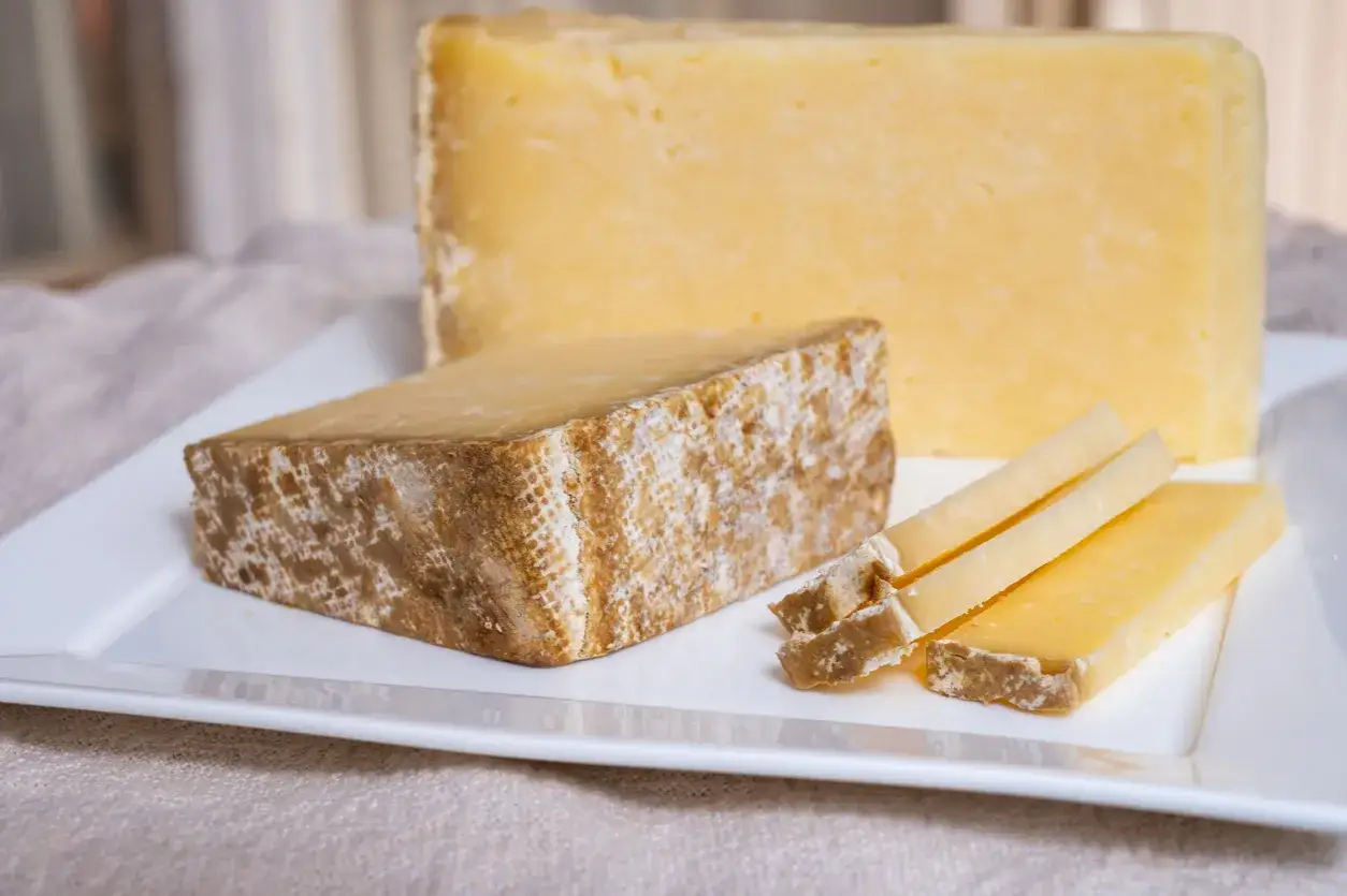 Tranches de Cantal, une des spécialités du Cantal, sur une assiette blanche.