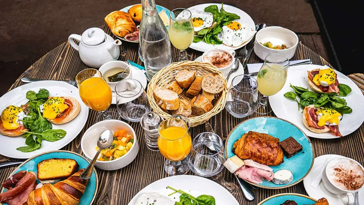 Un festin matinal parisien : œufs Bénédicte, croissants, jus d'orange et café. Un plat typique de Paris pour bien commencer la journée.