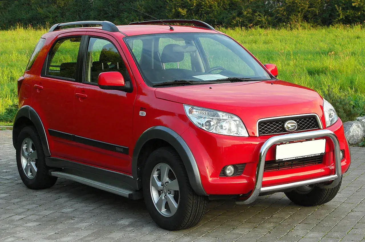 Czerwony Daihatsu Terios z metalowym orurowaniem z przodu, gotowy na przygodę.