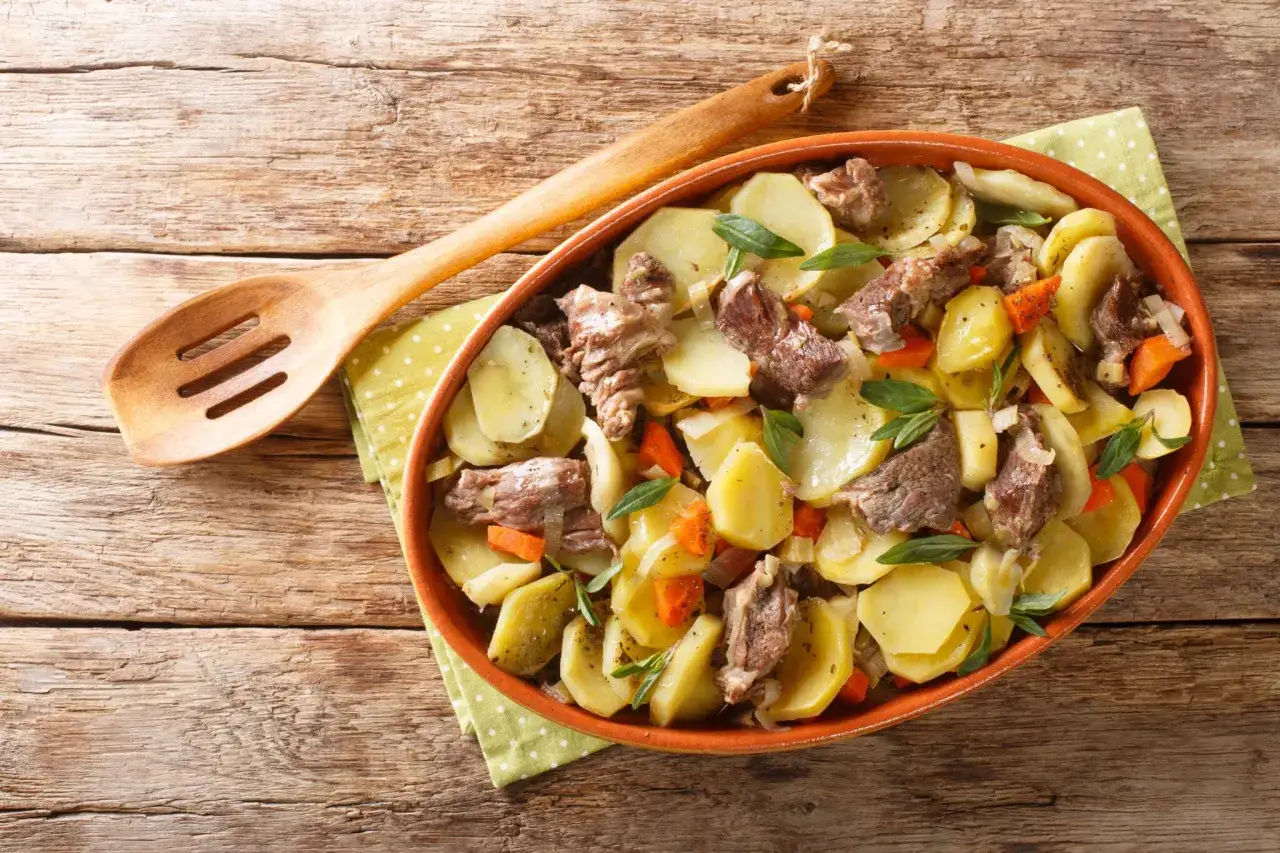 Un plat de pommes de terre et de viande mijotée, garni d'herbes fraîches, une spécialité alsace réconfortante.