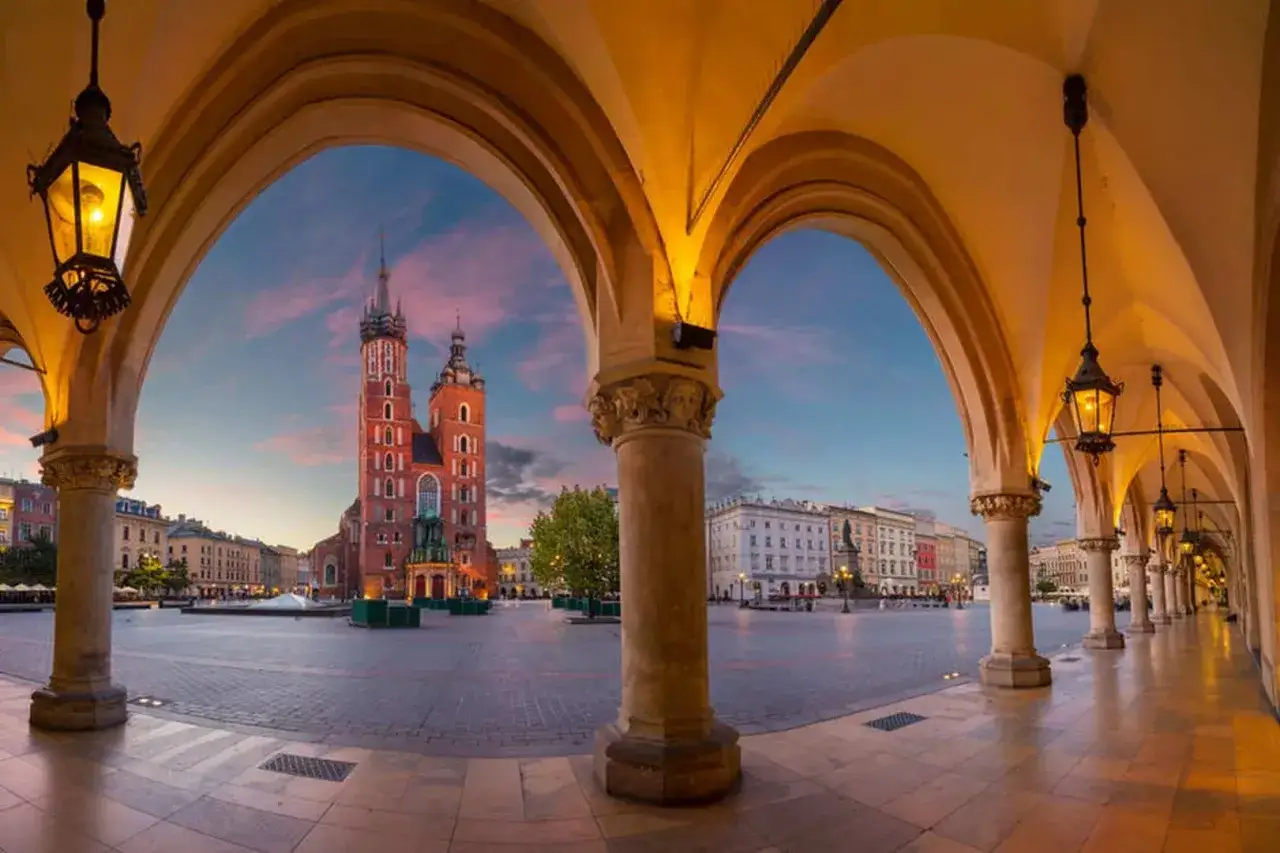 Sukiennice i Kościół Mariacki na Rynku Głównym w Krakowie o zachodzie słońca.