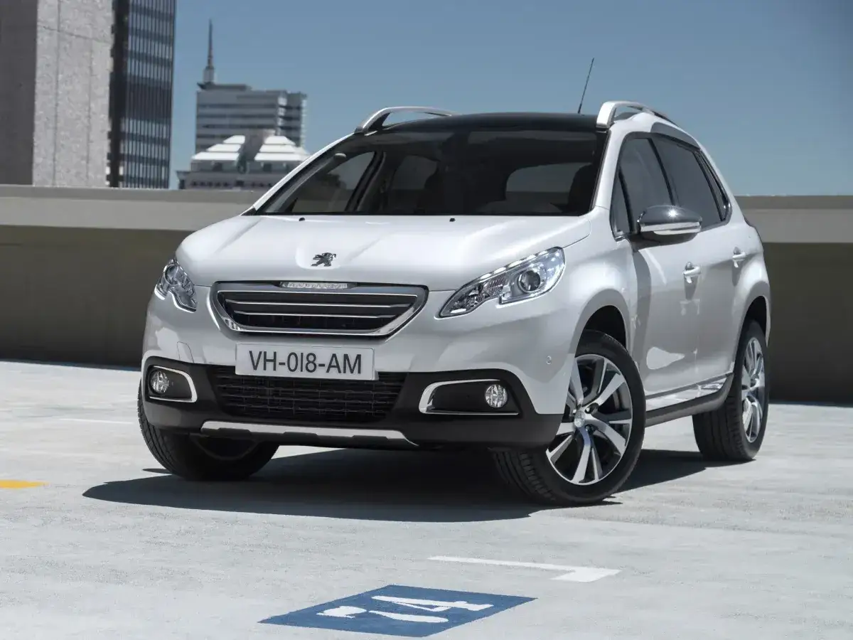 Biały Peugeot 2008, idealny SUV do 40 tys. zł, zaparkowany na dachu budynku.
