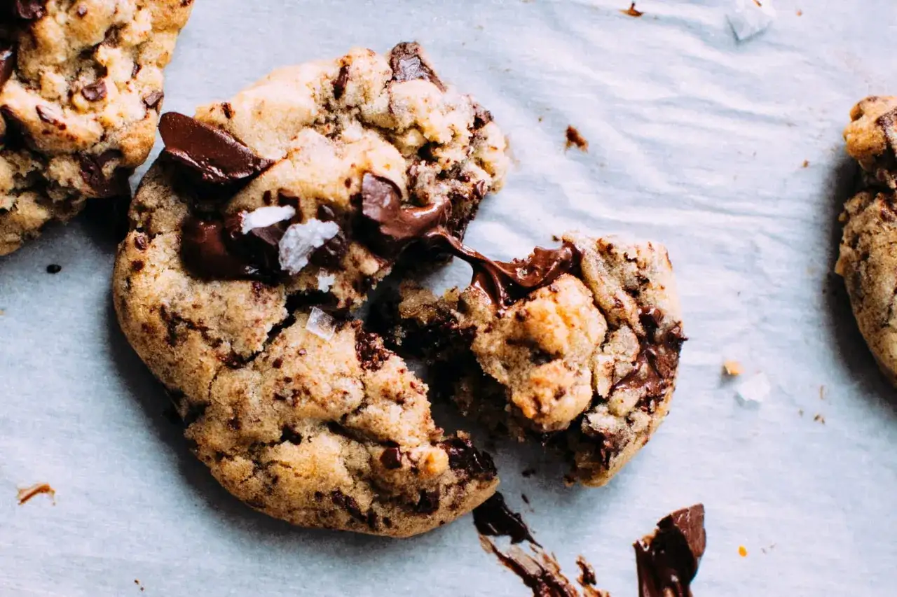 Des cookies aux pépites de chocolat fondantes, parfaits pour apprendre comment faire des cookies maison. Le chocolat coule, invitant à la dégustation.