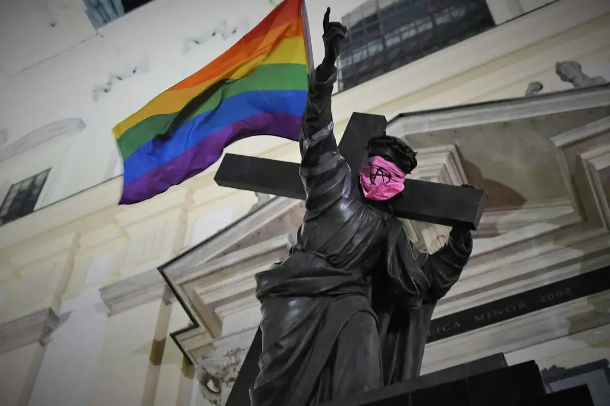 Pomnik z tęczową flagą i różową opaską na oczach. Symbolizuje walkę o równość i wolność, gdzie wiara i tęcza łączą się w jedno.