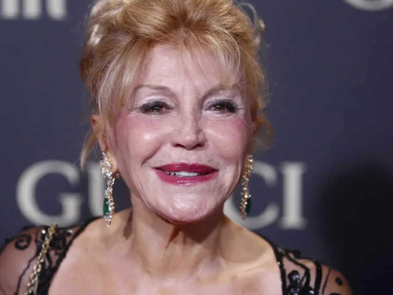 Tita Thyssen, con su melena rubia recogida y luciendo unos pendientes de brillantes y esmeraldas, sonríe a la cámara.