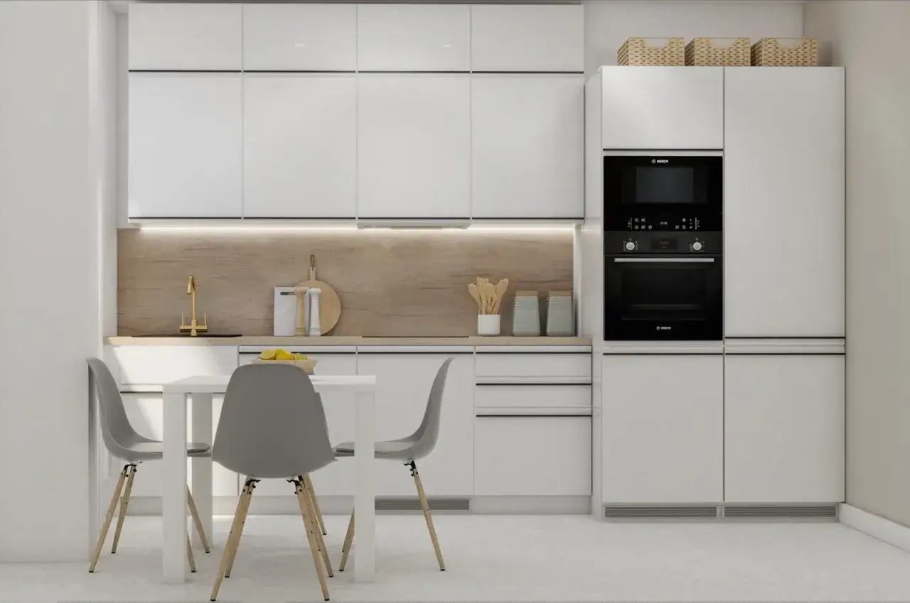 Nowoczesna kuchnia z białymi frontami, złotą baterią i sprytnymi schowkami w zabudowie.